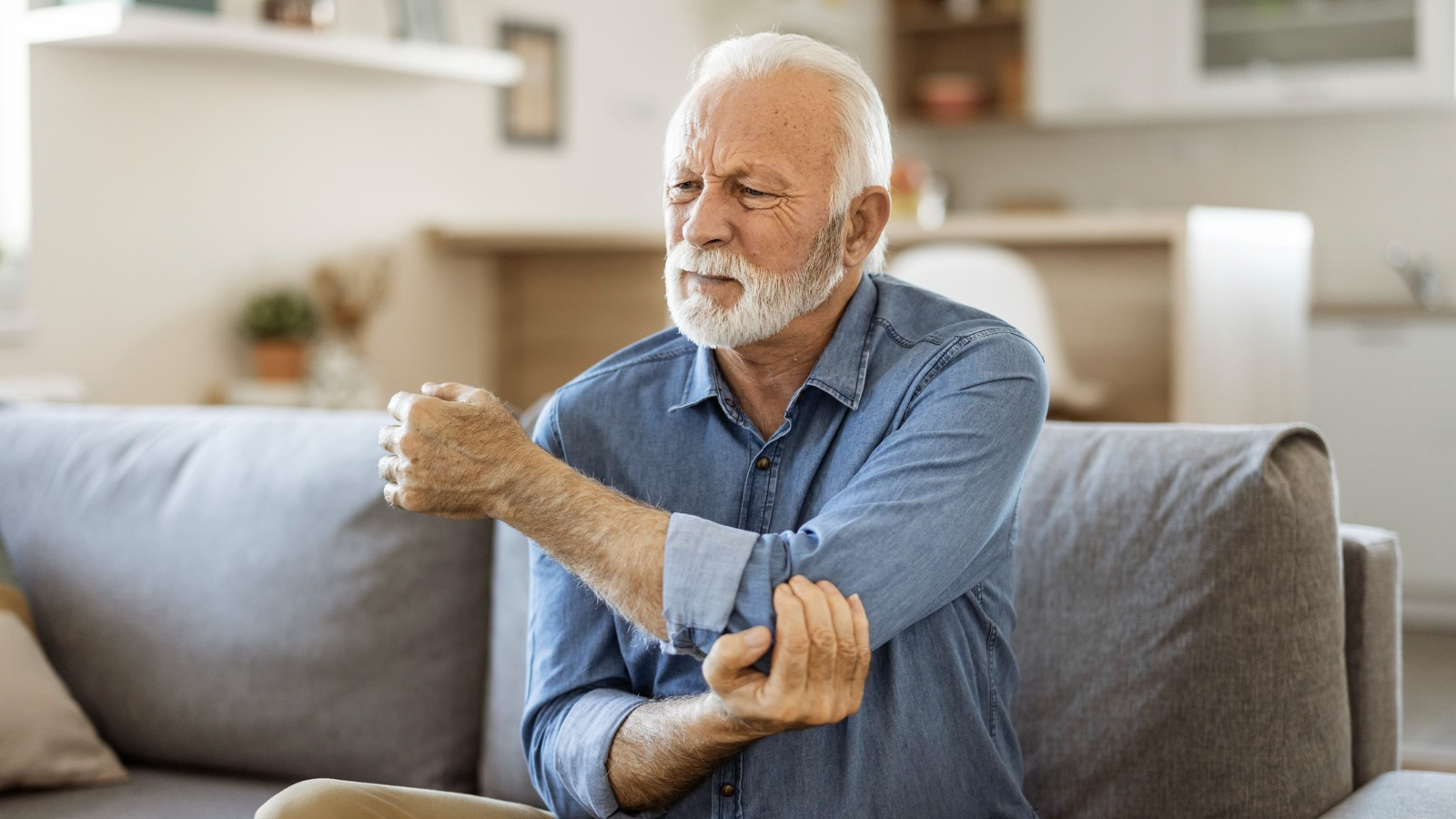 elder man holding elbow